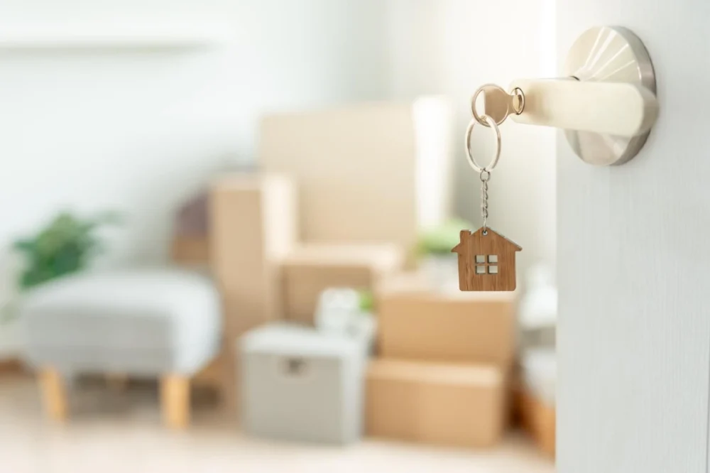 Apartment door key with moving boxes in the background