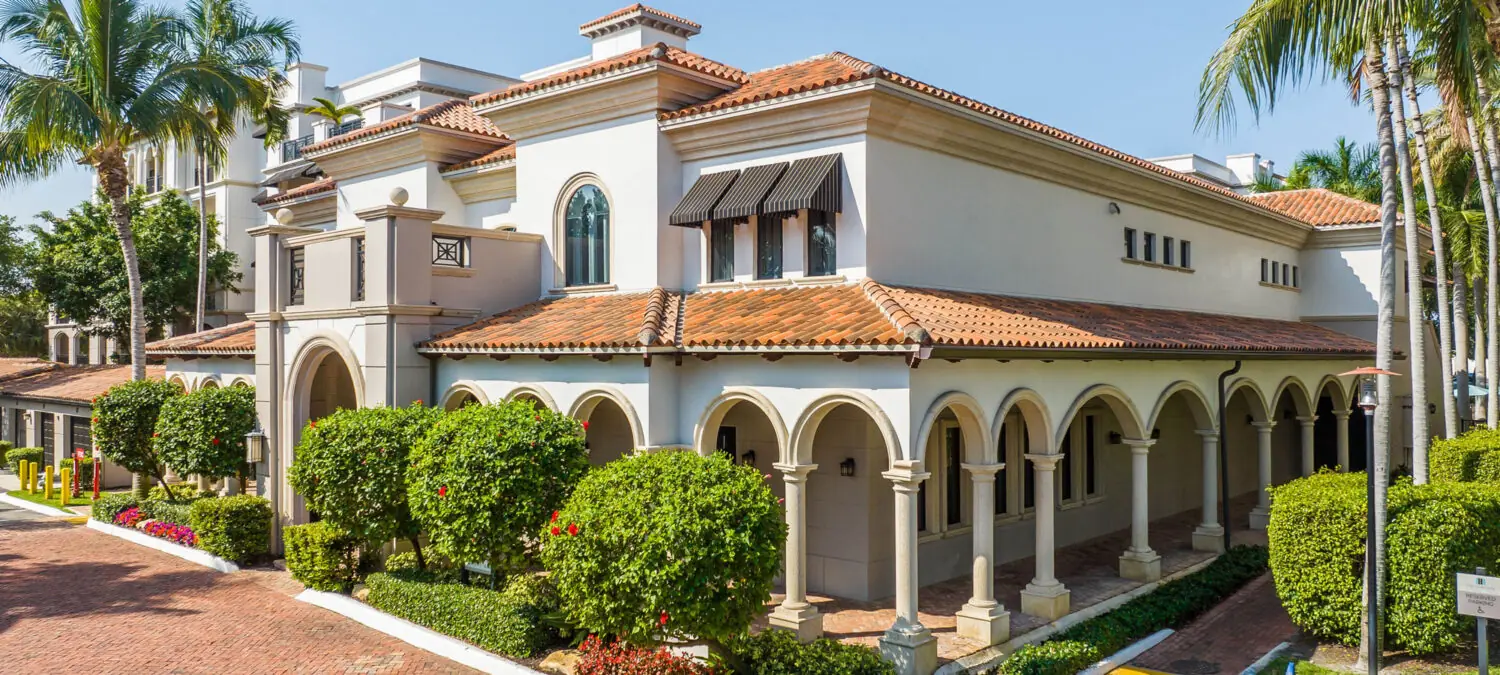 Heritage at Boca Raton apartment building exterior with arched entry and palm trees