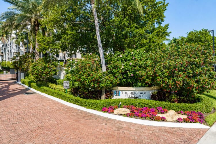 Landscaped entrance drive with flower beds at Heritage at Boca Raton
