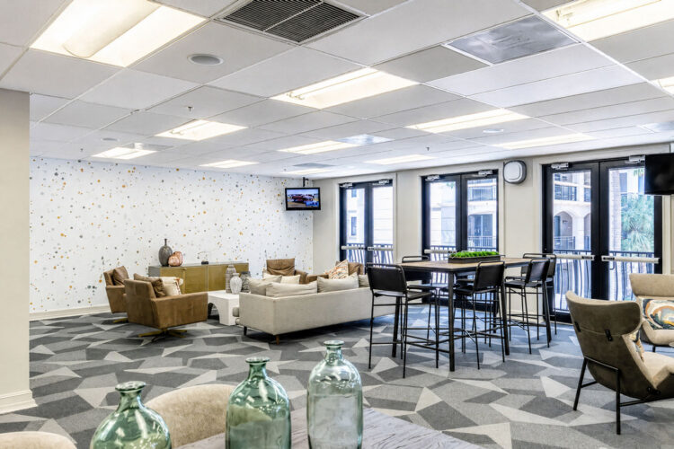 Clubhouse social room with lounge seating and tables at Heritage at Boca Raton