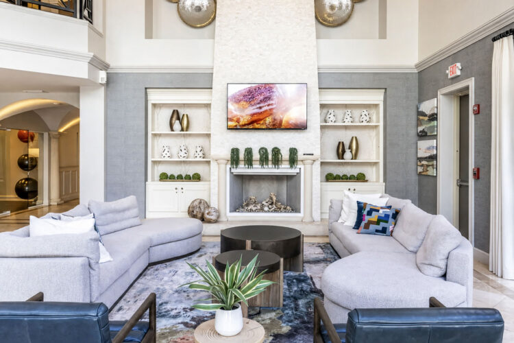 Resident clubhouse lounge with sectional sofa and built-in shelving at Heritage at Boca Raton