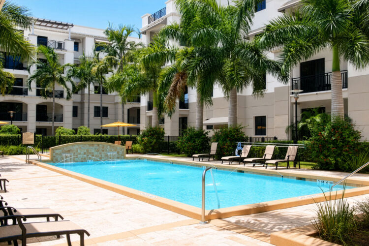 Resort-style pool with lounge chairs and palm trees at Heritage at Boca Raton