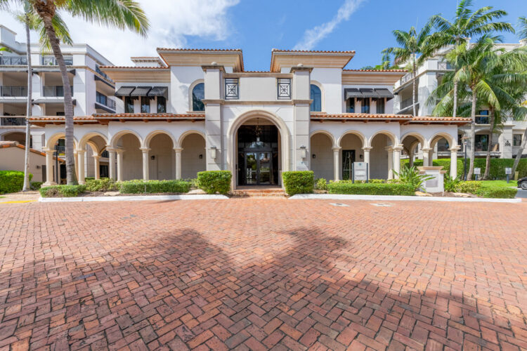 Front entrance with paver driveway and arched portico at Heritage at Boca Raton
