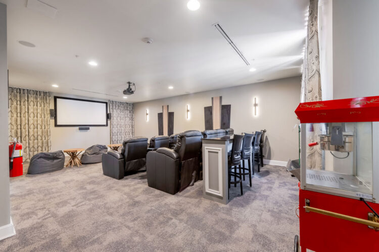 Movie theater with recliner seating and popcorn machine at Heritage at Boca Raton