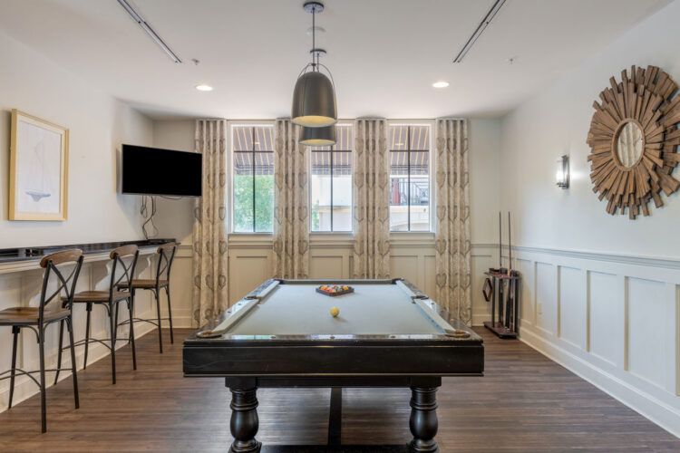 Billiards room with pool table and bar seating at Heritage at Boca Raton