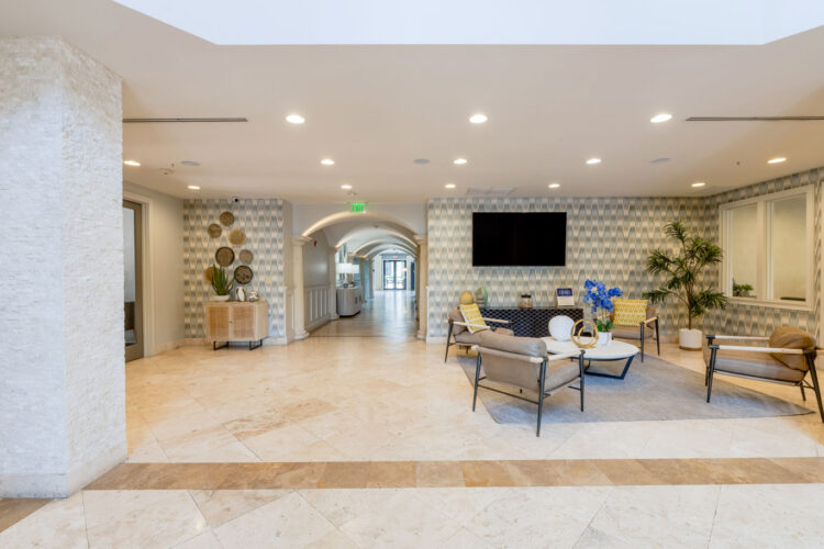 Lobby lounge with arched doorways and TV at Heritage at Boca Raton
