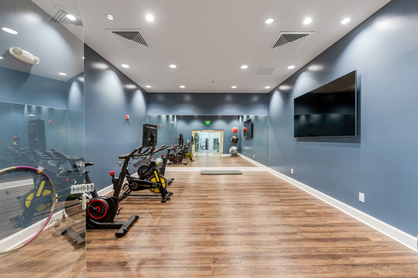 Fitness center with spin bikes and wood floors at Heritage at Boca Raton